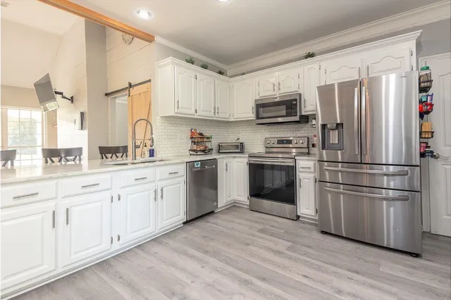 a kitchen with cabinets stainless steel appliances and window