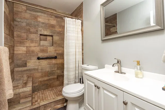 a bathroom with a sink a toilet and shower