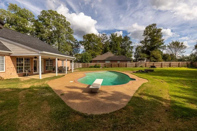 a view of a house with swimming pool and yard