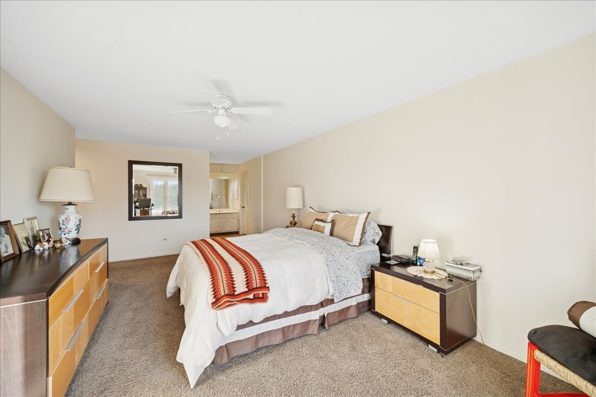 1771 Mission Hills Road, Unit 212 Northbrook, IL 60062 - Photo 16 of 22 a bedroom with a bed and a chandelier
