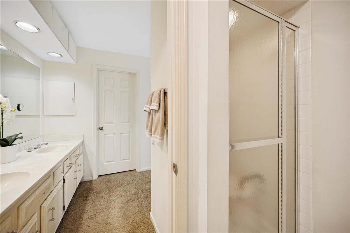 1771 Mission Hills Road, Unit 212 Northbrook, IL 60062 - Photo 18 of 22 a view of a bathroom with a sink a mirror and a shower