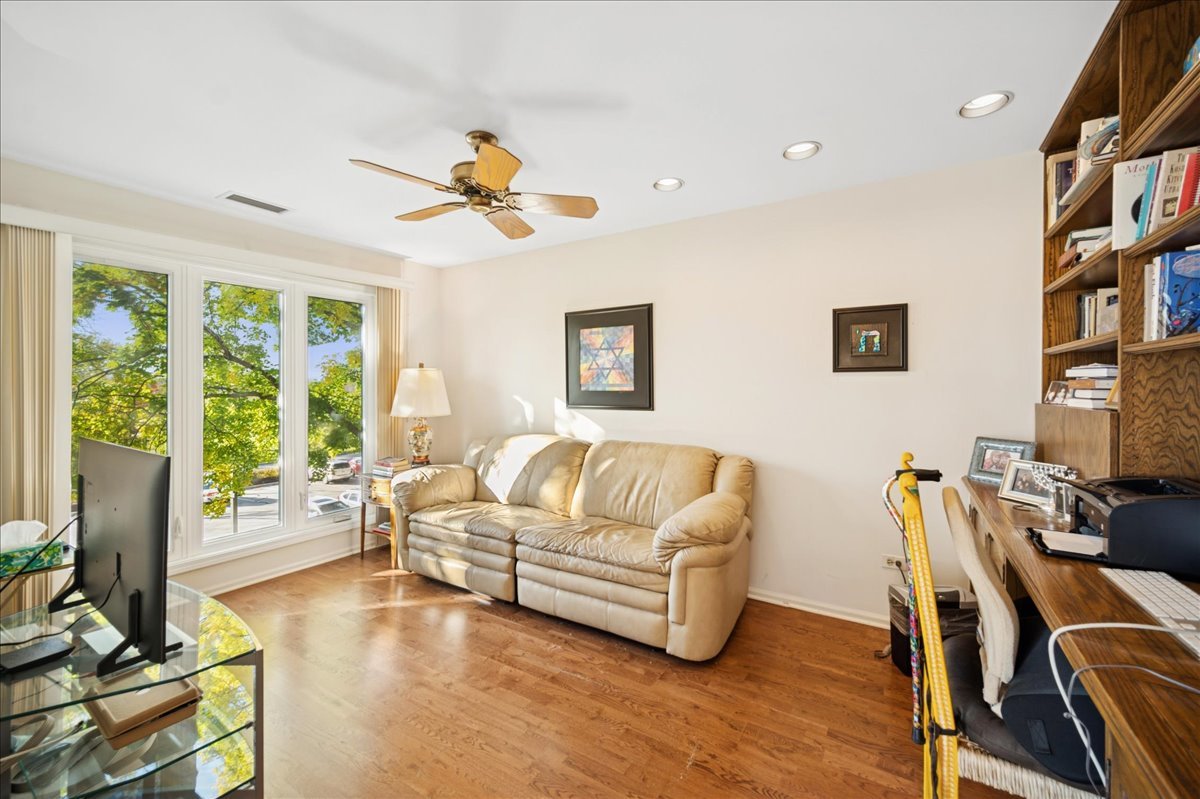 1771 Mission Hills Road, Unit 212 Northbrook, IL 60062 - Photo 8 of 22 a living room with furniture a floor to ceiling window and a flat screen tv