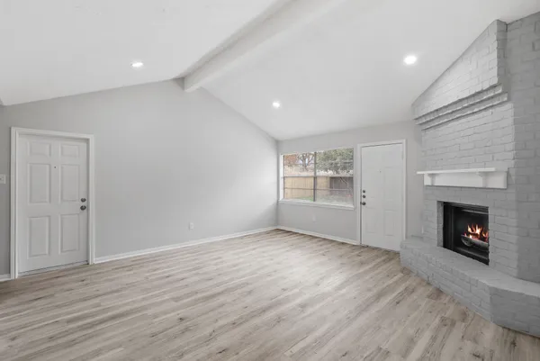 a view of an empty room with window and fire place