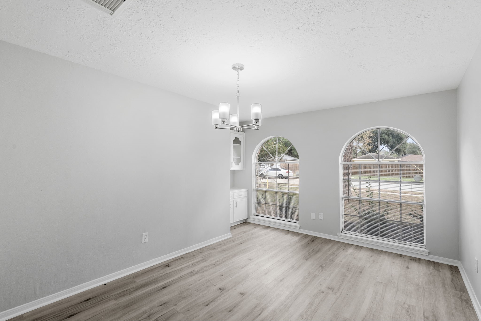 23111 Canyon Lake Drive Spring, TX 77373 - Photo 14 of 24 Dining room at the front of the home showcases arched windows, cabinets for storage, and an updated light fixture, providing an attractive setting for both everyday meals and special occasions.