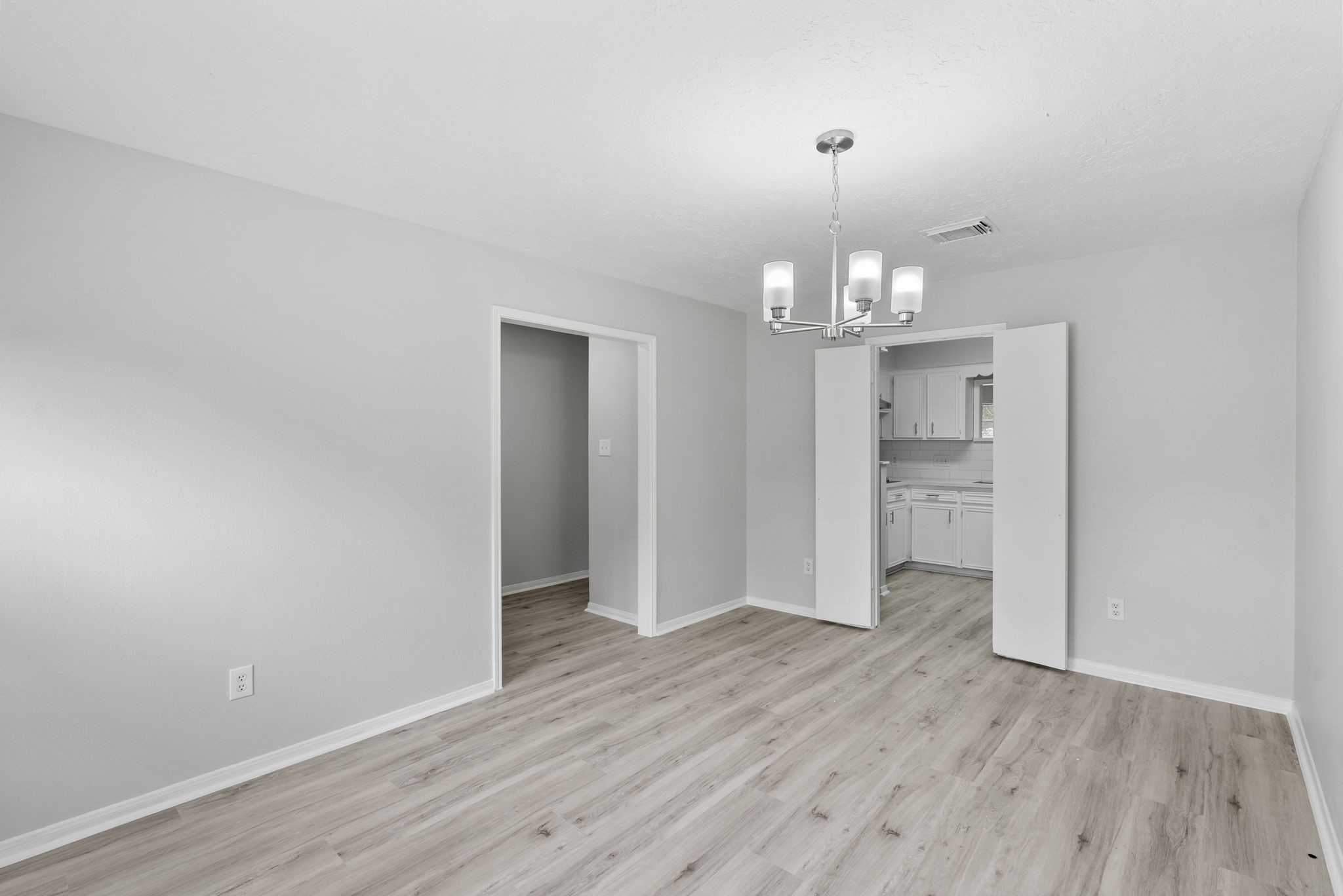 23111 Canyon Lake Drive Spring, TX 77373 - Photo 15 of 24 Dining room with updated light fixture, neutral paint, and continuous wood-look flooring that ties into the adjoining spaces. This room sits off of the front entry and is adjoined to the kitchen.