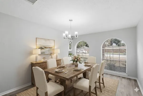 a view of a dining room with furniture a chandelier and wooden floor
