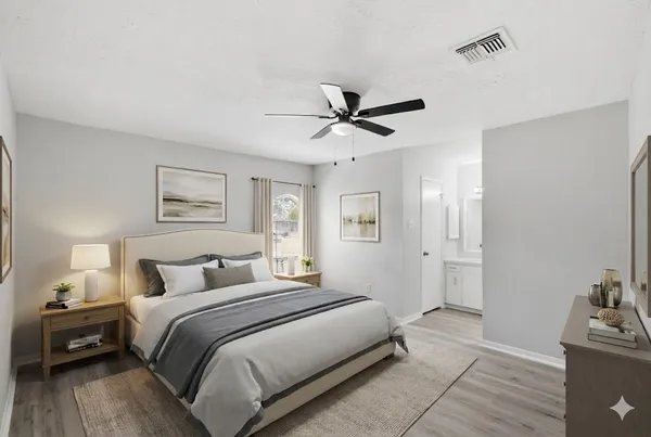 a bedroom with a large bed and a chandelier