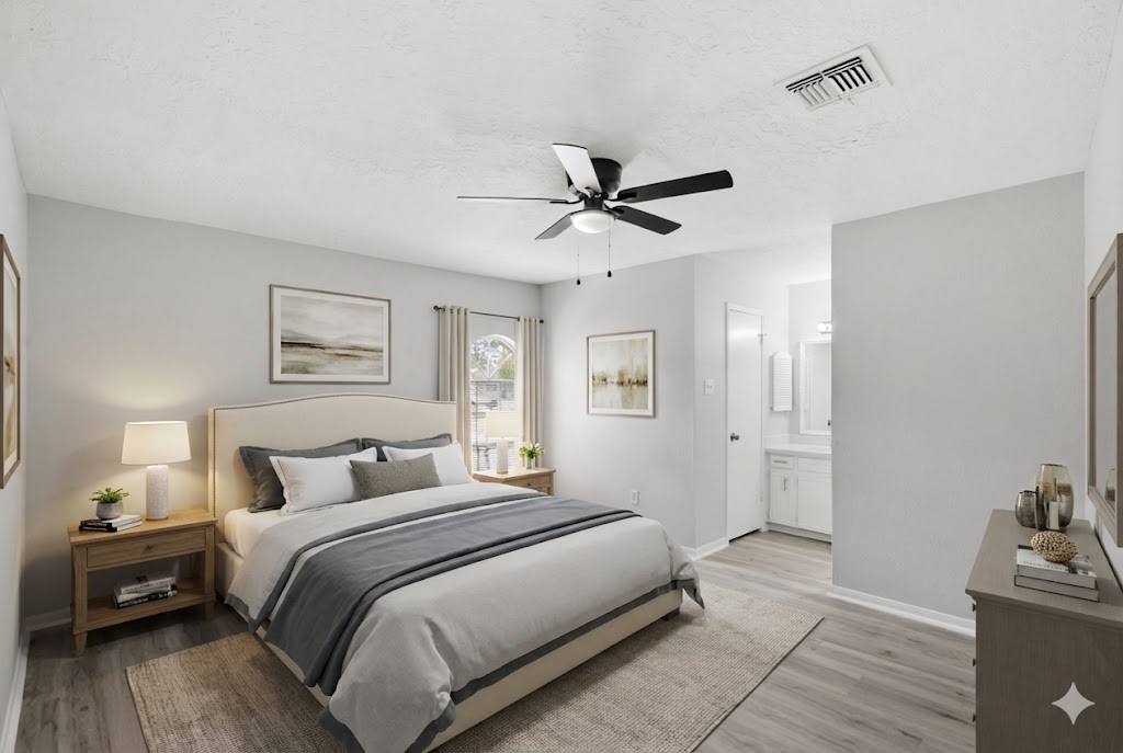 23111 Canyon Lake Drive Spring, TX 77373 - Photo 5 of 24 Primary bedroom with ceiling fan, neutral wall color, and wood-look flooring. Room offers direct access to an en-suite vanity area and closet, and is virtually staged to show a possible bed placement.