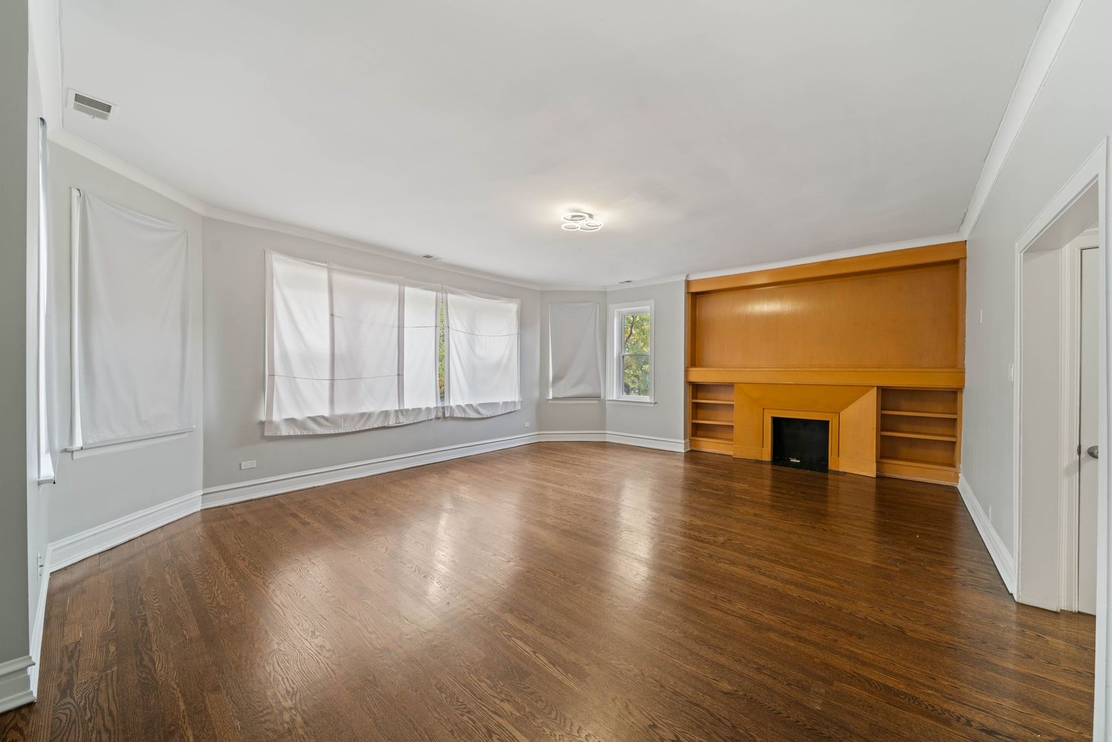 5426 West Jackson Boulevard, Unit 2 Chicago, IL 60644 - Photo 2 of 10 a view of empty room with wooden floor and fireplace