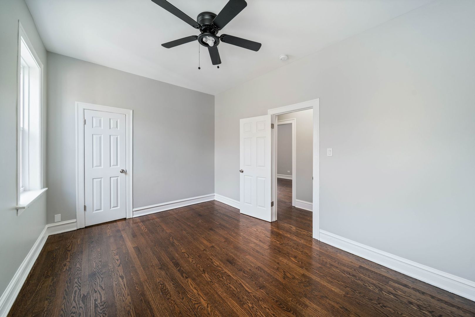 5426 West Jackson Boulevard, Unit 2 Chicago, IL 60644 - Photo 5 of 10 an empty room with wooden floor and windows