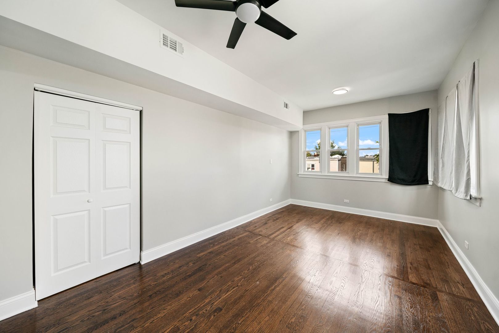 5426 West Jackson Boulevard, Unit 2 Chicago, IL 60644 - Photo 9 of 10 a view of an empty room with a window and wooden floor