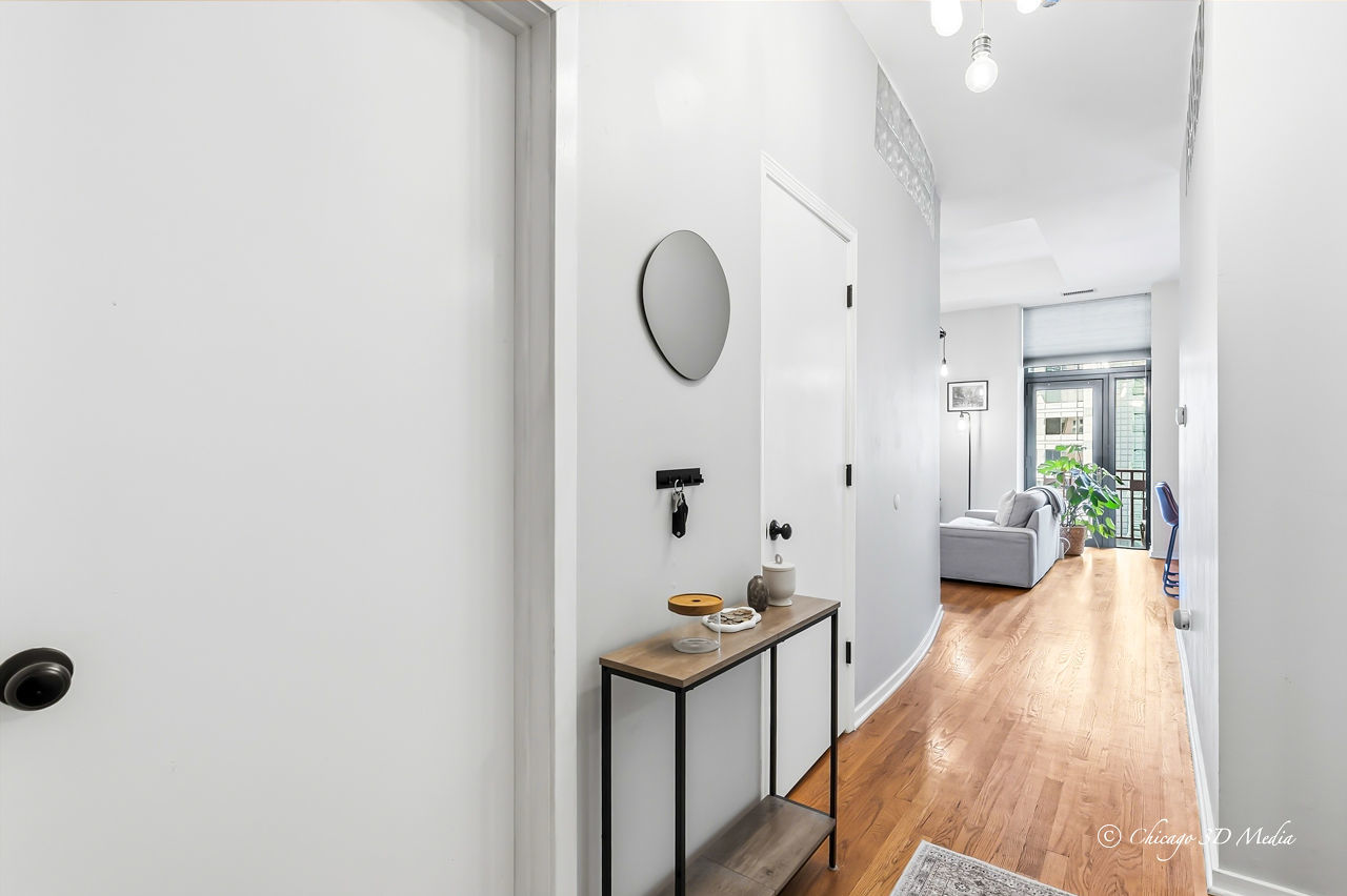 208 West Washington Street, Unit 1007 Chicago, IL 60606 - Photo 6 of 18 a view of a hallway with wooden floor and furniture