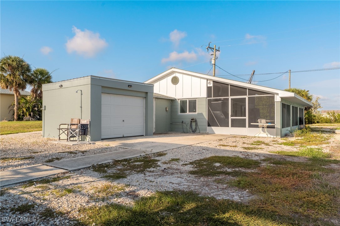 16341 Porto Bello Street Bokeelia, FL 33922 - Photo 22 of 50 a front view of a house with a yard and garage