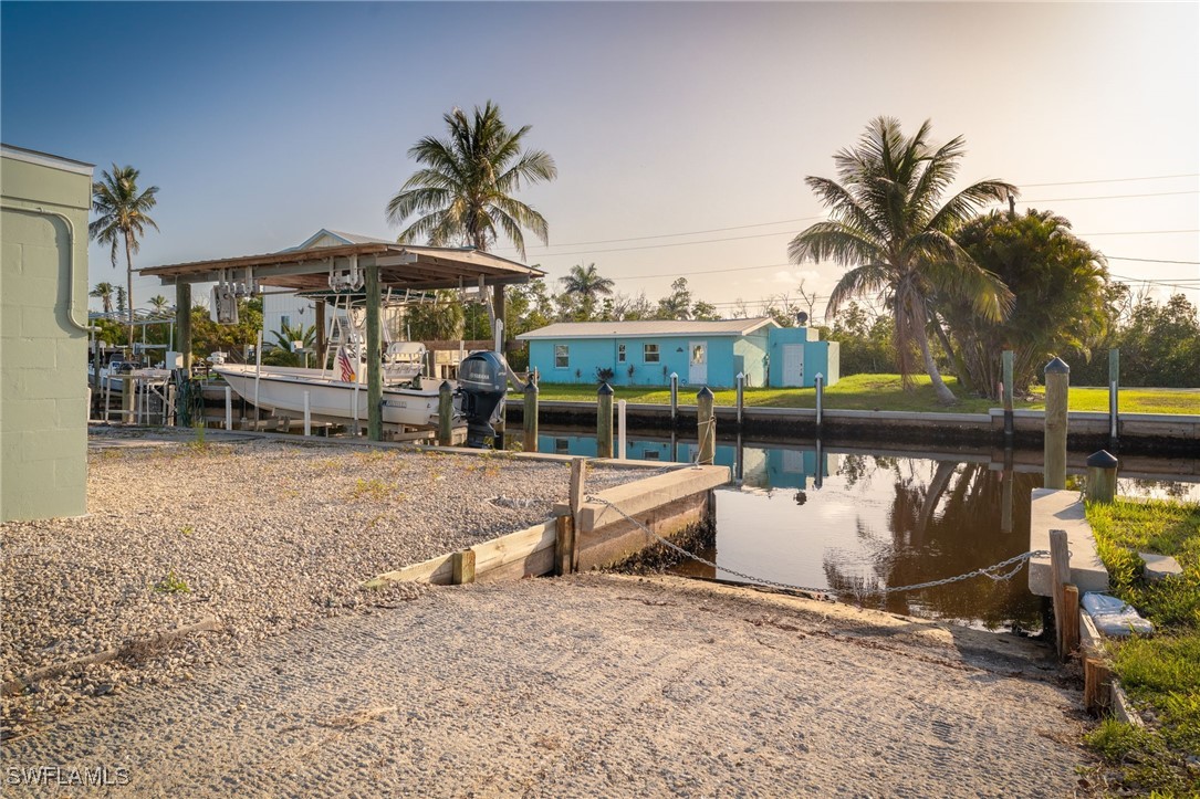 16341 Porto Bello Street Bokeelia, FL 33922 - Photo 25 of 50 a view of a swimming pool with a table and chairs under an umbrella