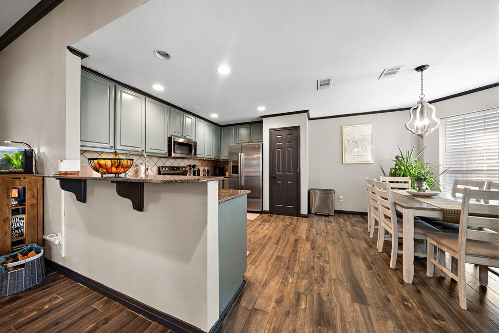 10512 Whitney Trace Drive Waco, TX 76708 - Photo 25 of 39 Open-concept kitchen and dining area featuring wood-finish flooring, recessed lighting, and a breakfast bar
