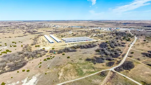 a view of a dry yard with wooden fence