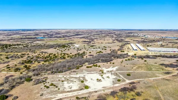 a view of a dry yard with wooden fence