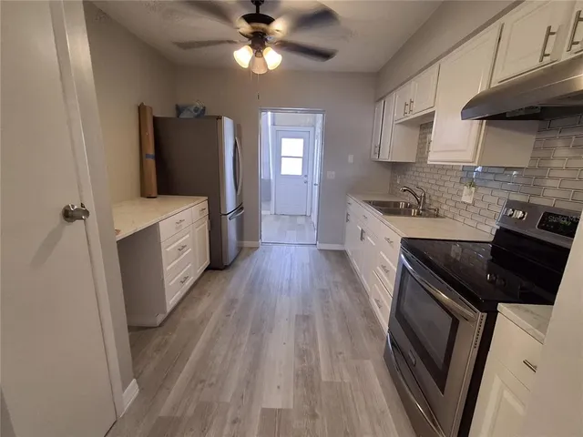 a kitchen with a stove a sink and a refrigerator