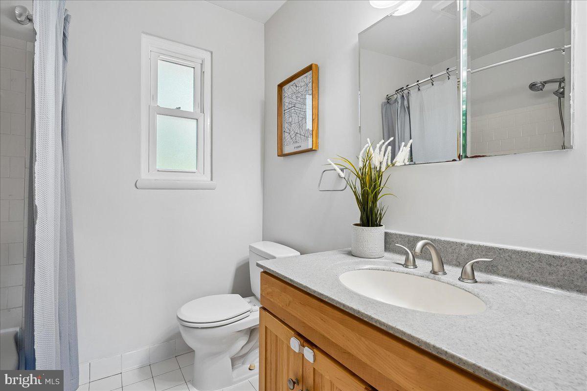 104 Belton Road Silver Spring, MD 20901 - Photo 41 of 56 a bathroom with a granite countertop toilet sink and mirror
