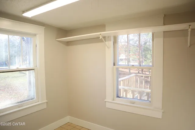 an empty room with windows and closet