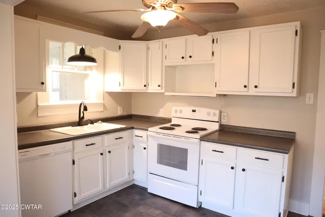 a kitchen with cabinets appliances a sink and a window
