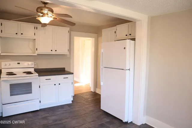 a kitchen with a refrigerator sink and cabinets