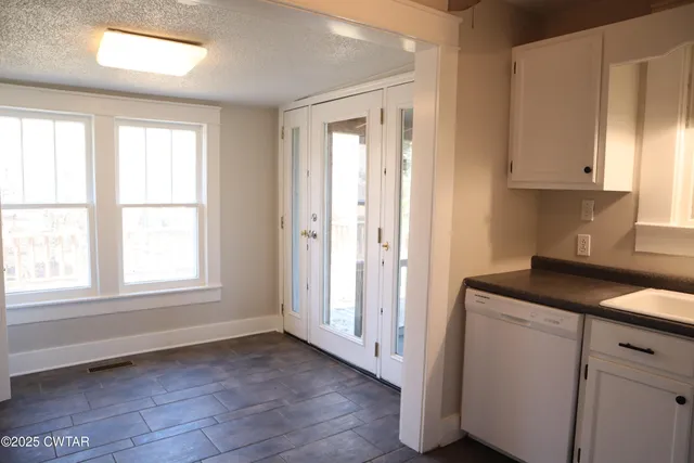 a view of a kitchen with wooden floor and cabinets