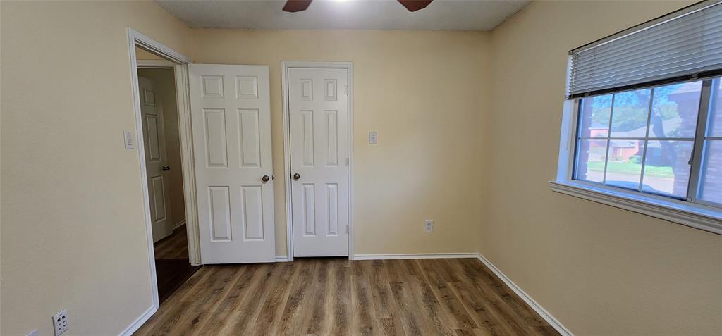 2413 Timber Ridge Lane Flower Mound, TX 75028 - Photo 14 of 16 Wood-finish flooring, light-toned wall paint, ceiling fan, white paneled doors, and a window with blinds