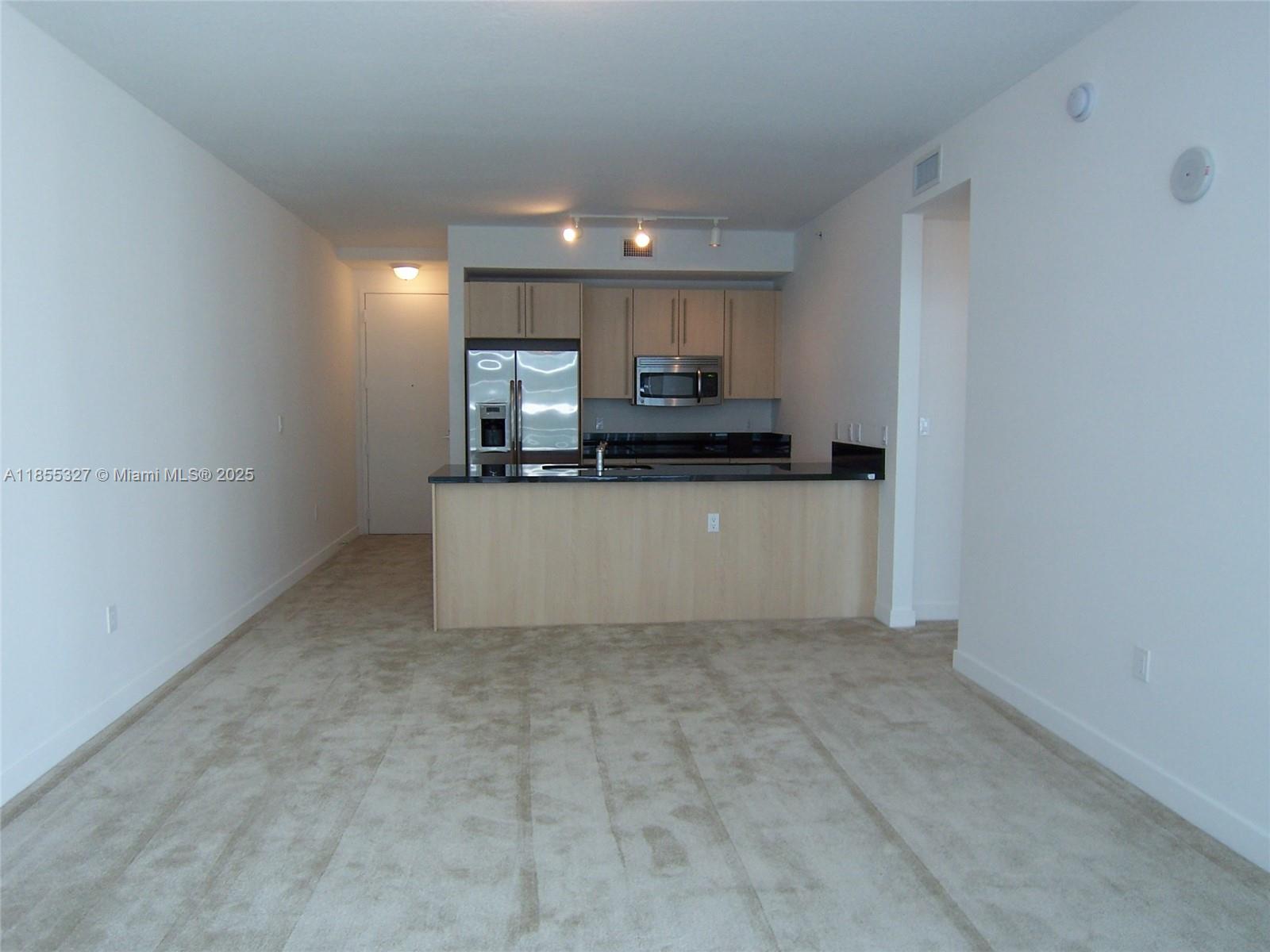 1111 Southwest 1st Avenue, Unit 3415N Miami, FL 33130 - Photo 3 of 11 a kitchen with stainless steel appliances a sink a stove a microwave a sink a refrigerator and cabinets