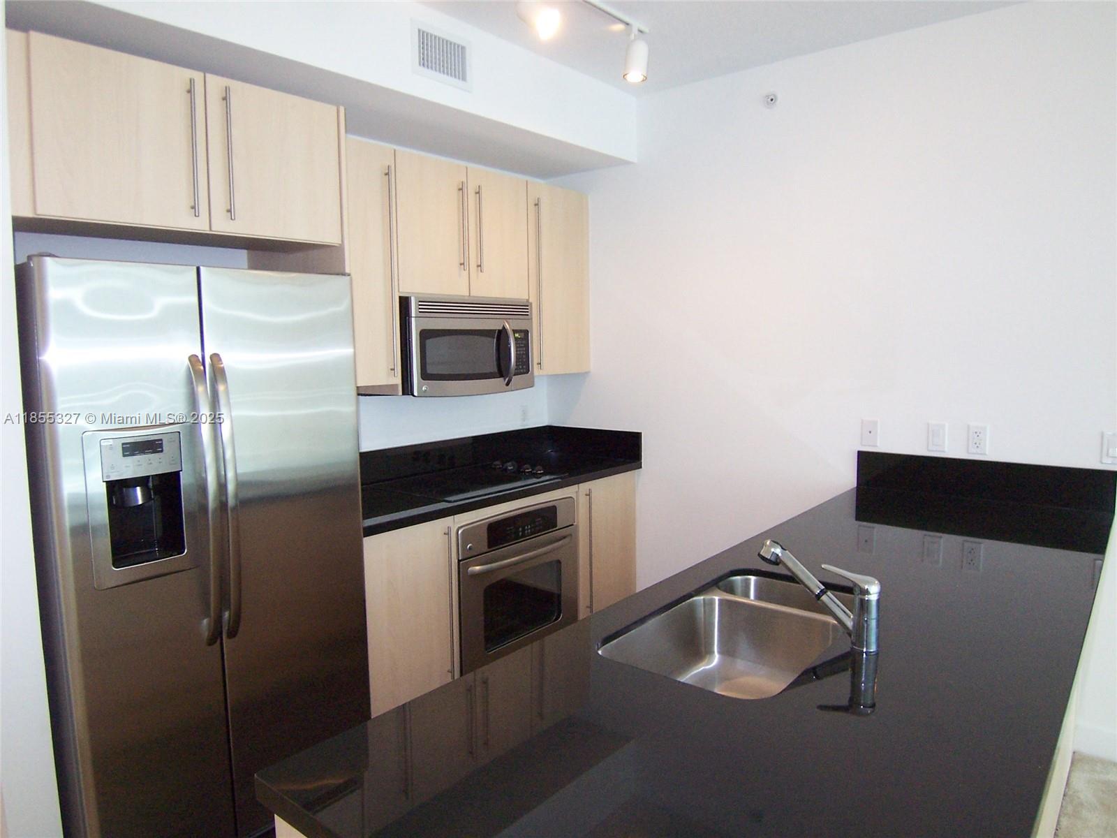 1111 Southwest 1st Avenue, Unit 3415N Miami, FL 33130 - Photo 4 of 11 a kitchen with stainless steel appliances a refrigerator sink and microwave