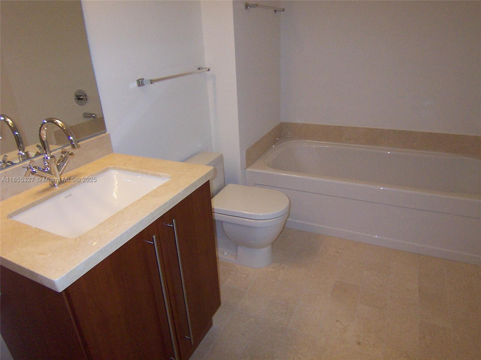 1111 Southwest 1st Avenue, Unit 3415N Miami, FL 33130 - Photo 5 of 11 a bathroom with a sink a toilet and shower
