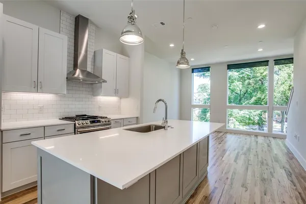 a kitchen with stainless steel appliances a sink stove and cabinets