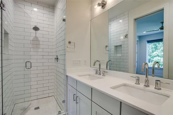 a bathroom with a sink shower and a mirror