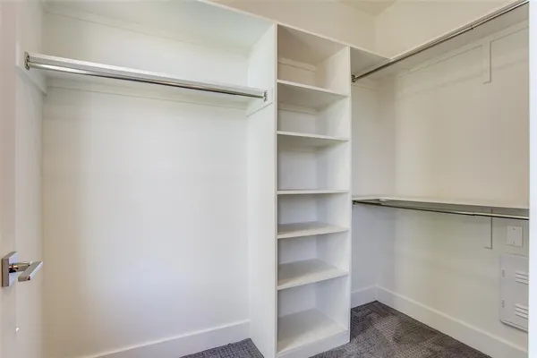 a view of walk in closet with empty racks