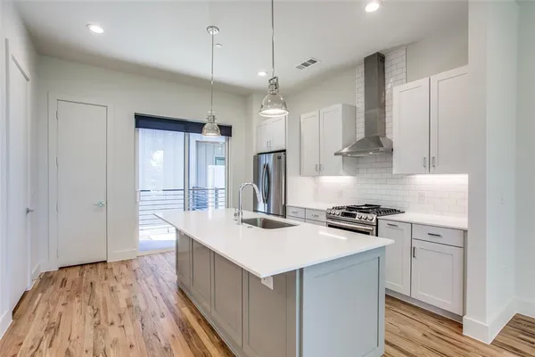 a kitchen that has a lot of cabinets in it and wooden floors