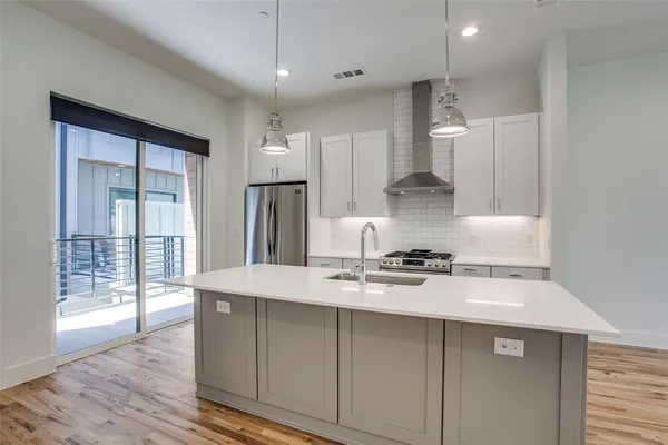 a kitchen with stainless steel appliances granite countertop a sink stove and refrigerator