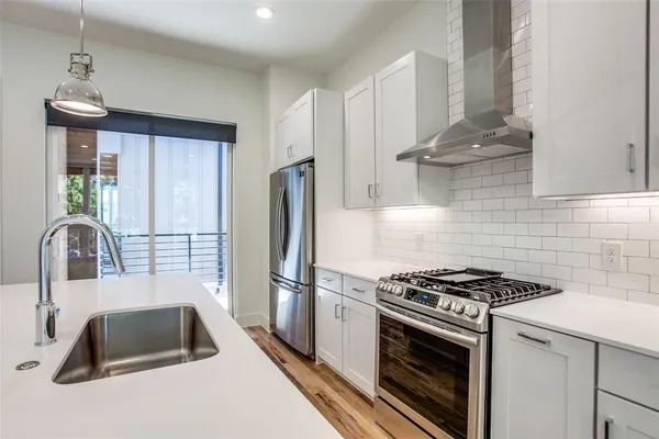 a kitchen with granite countertop a sink stainless steel appliances and cabinets
