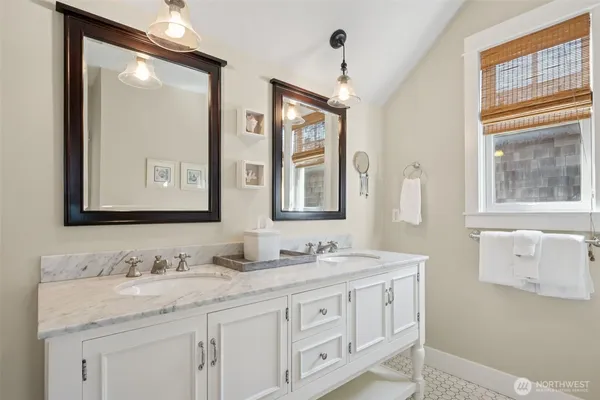 a bathroom with double sink and a mirror