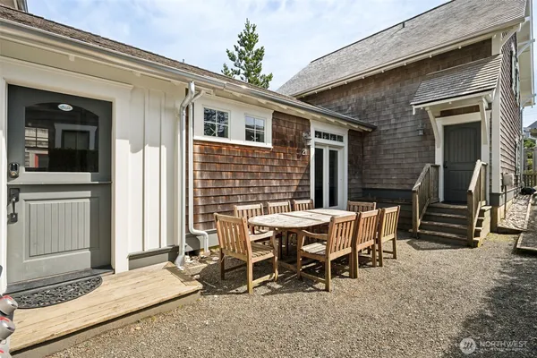 a patio with table and chairs and potted plants