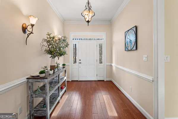 a view of a hallway with wooden floor and a potted plant
