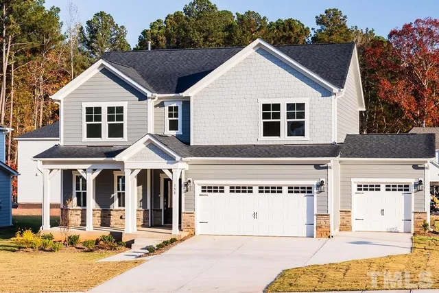 a view of a house with a yard and potted plants