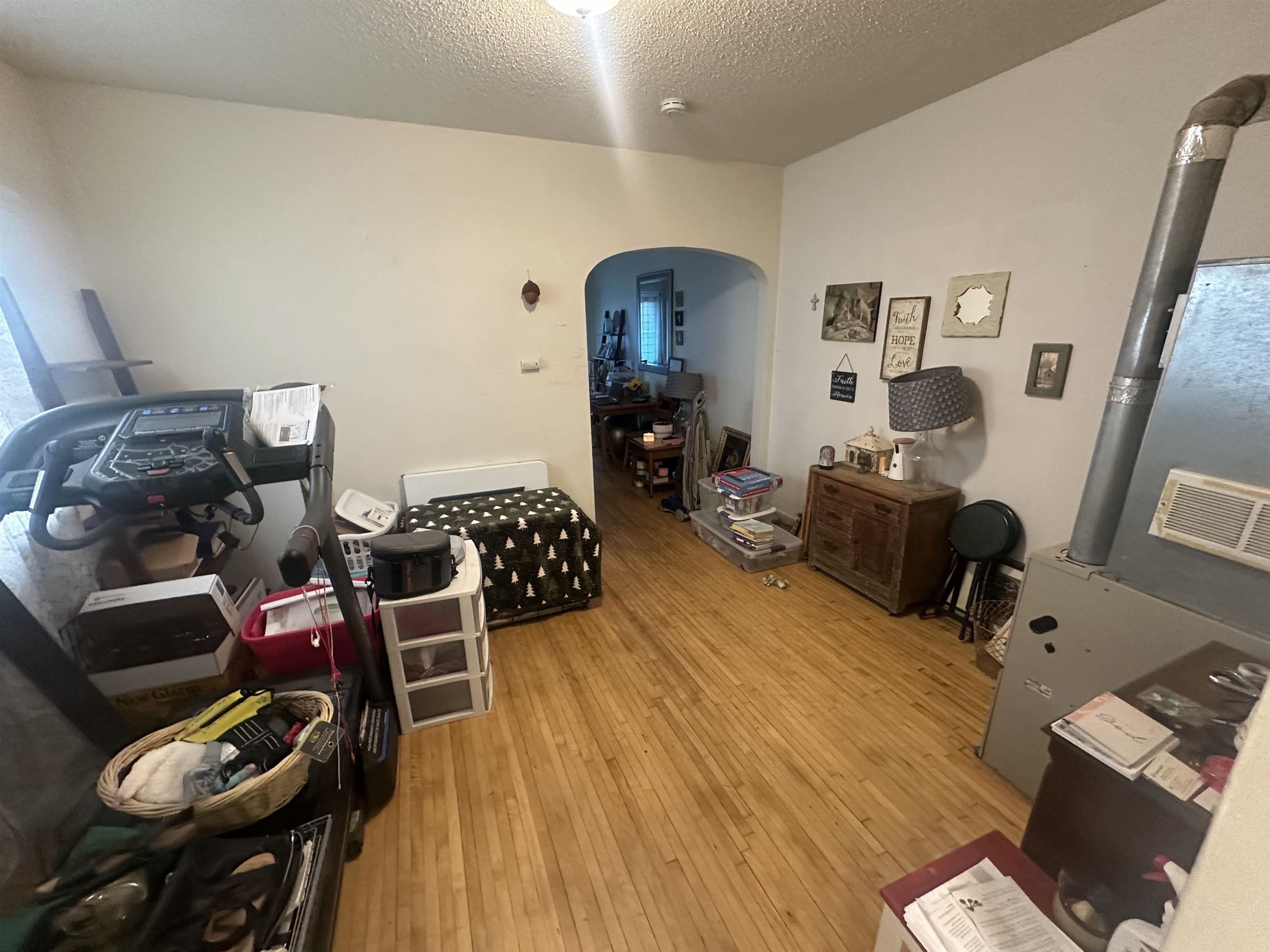 3512 Belknap Street Superior, WI 54880 - Photo 19 of 24 Misc room featuring arched walkways, light wood-style flooring, heating unit, and a textured ceiling