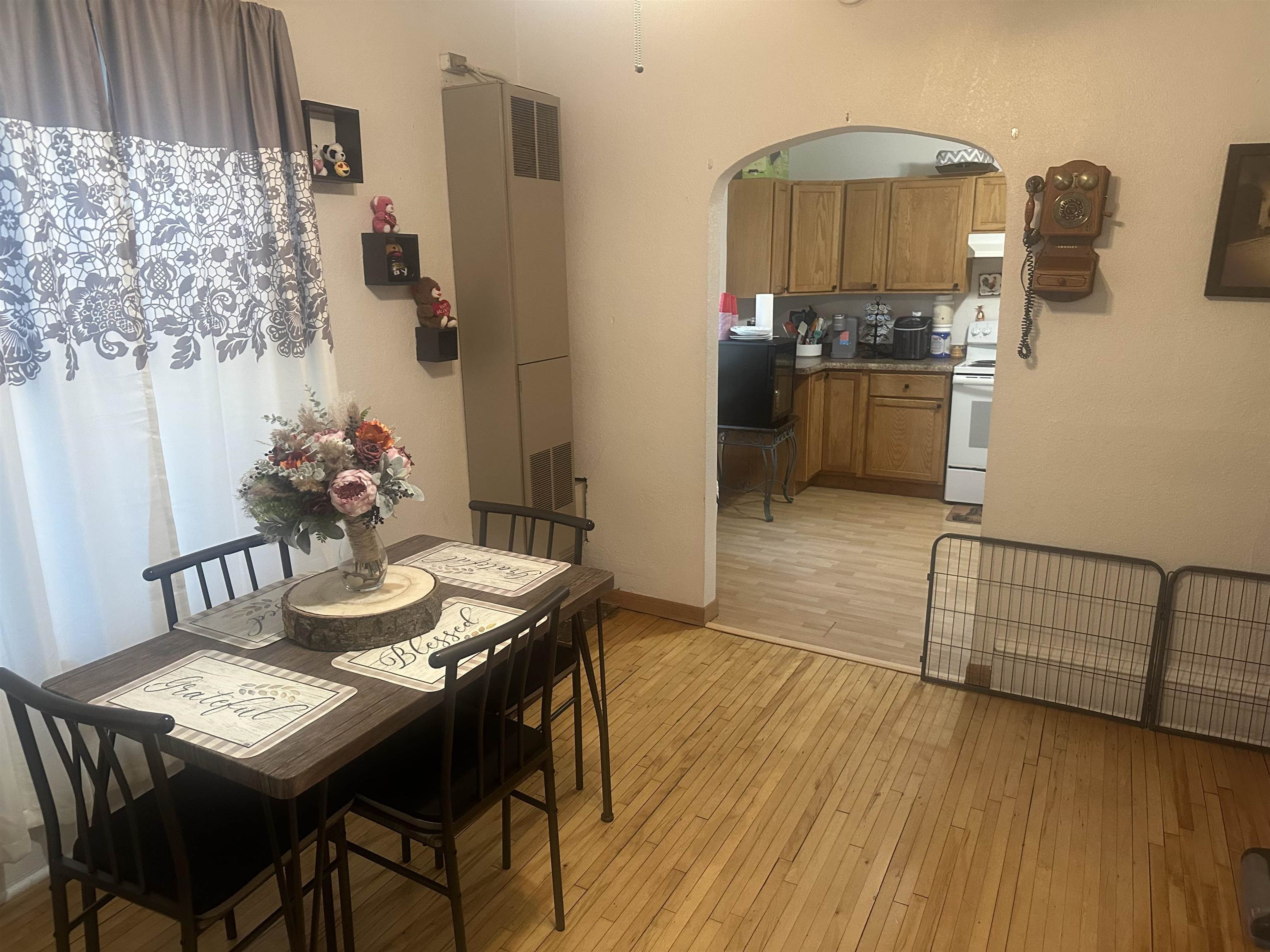 3512 Belknap Street Superior, WI 54880 - Photo 10 of 24 Dining room featuring light wood-style floors, arched walkways, a heating unit, and electric panel
