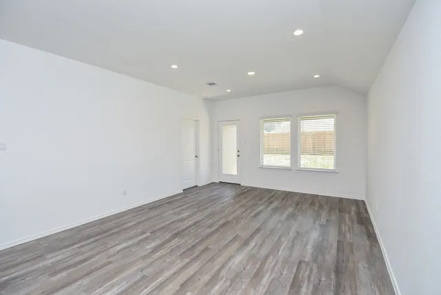 a view of empty room with wooden floor