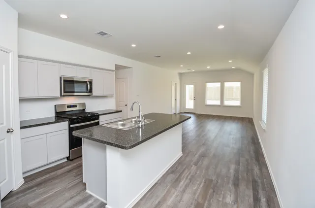 a kitchen with granite countertop a sink and a stove top oven