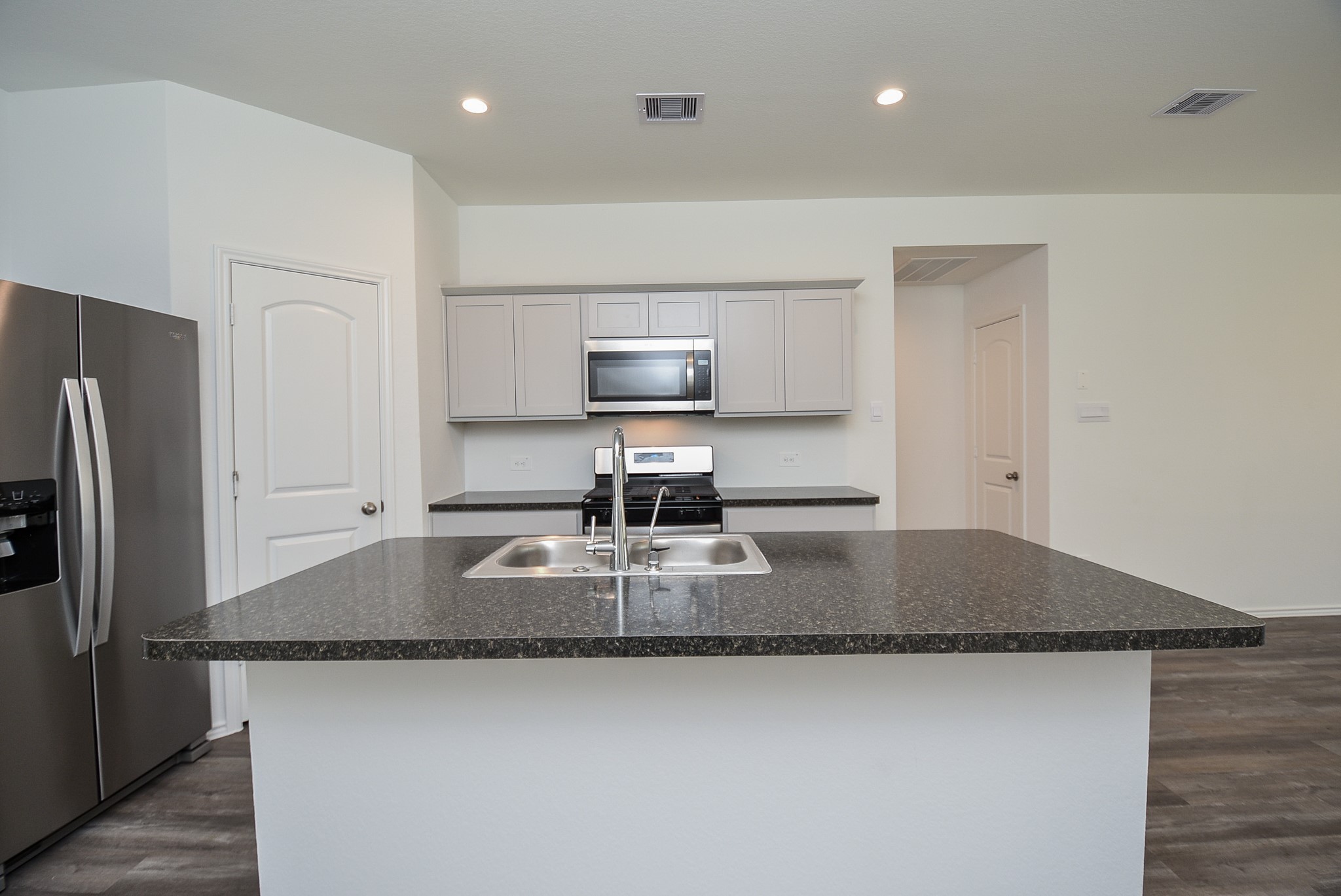 5718 Sycamore Glen Dr Spring Spring, TX 77373 - Photo 3 of 33 a kitchen with kitchen island a counter top space a sink and refrigerator