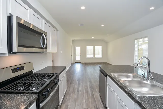 a bathroom with a granite countertop sink a mirror and wooden floor