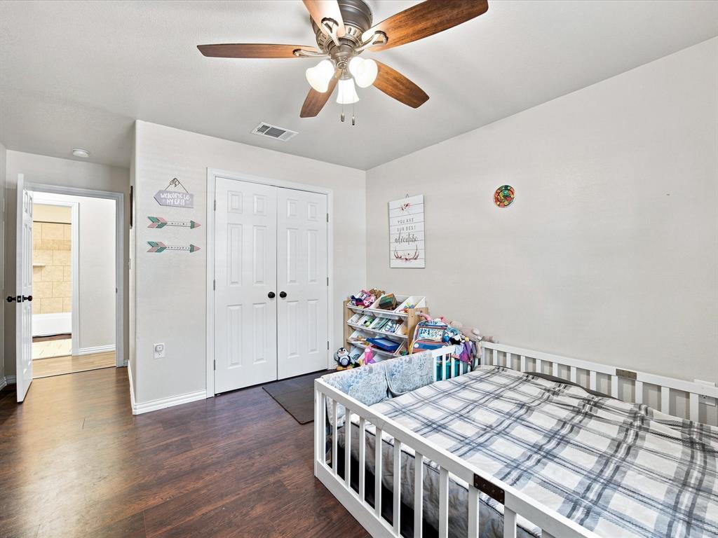 408 Inwood Road Azle, TX 76020 - Photo 17 of 32 Wood-finish flooring, ceiling fan with integrated lighting, white paneled bifold closet doors, and a white interior door with dark hardware