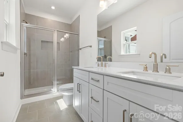 a bathroom with a shower sink vanity granite and toilet