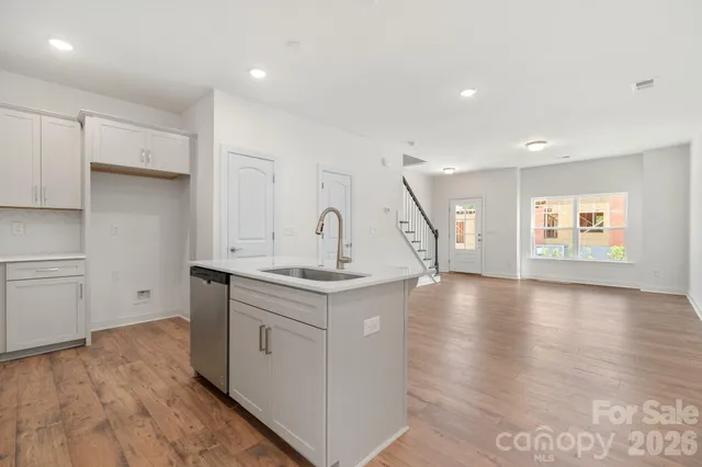 a kitchen with a sink and wooden floor